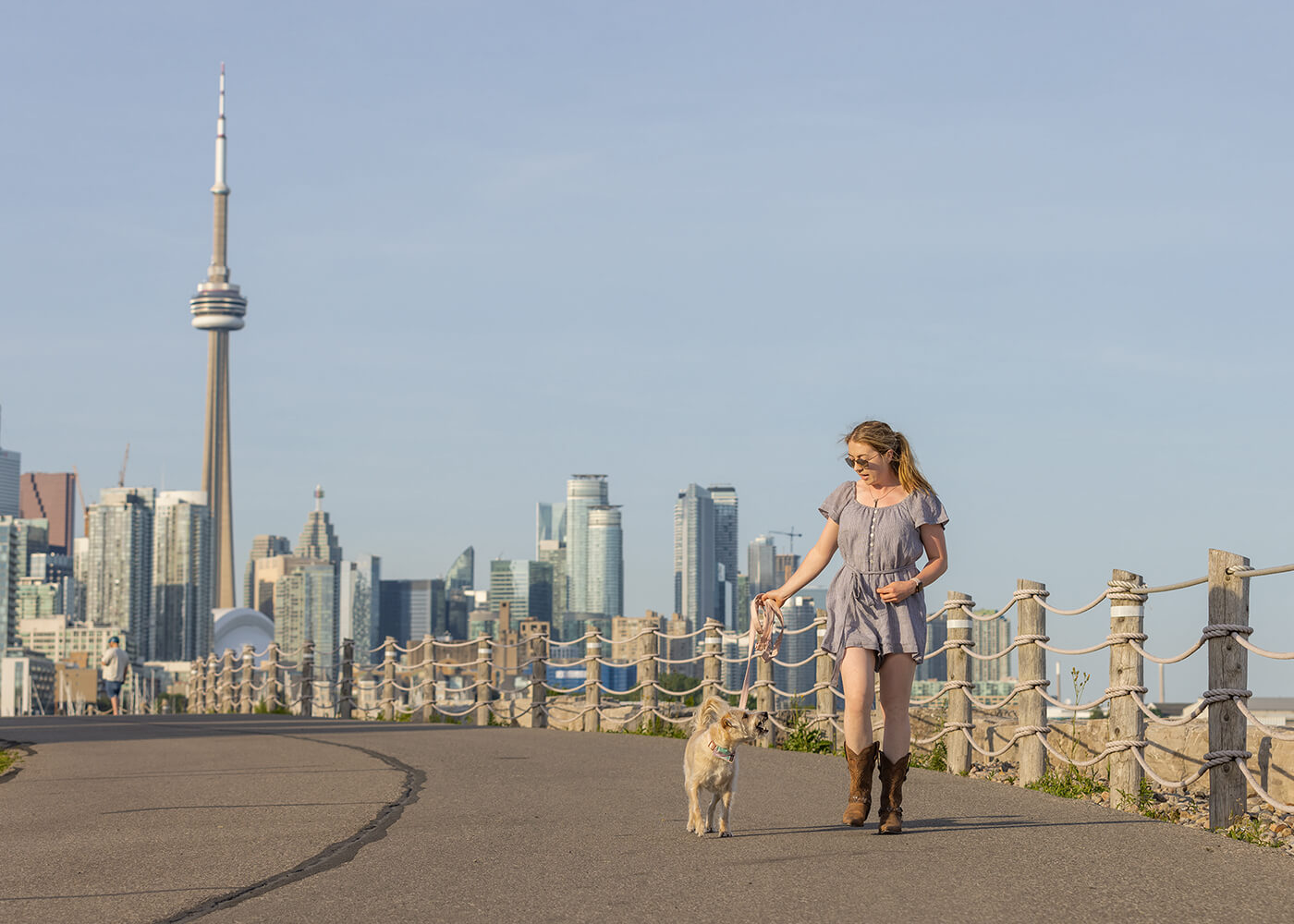 dog mom walking downtown with dog in front of CN Tower